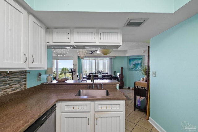 kitchen with dishwasher, decorative backsplash, white cabinetry, sink, and light tile patterned floors