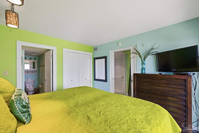 bedroom featuring a closet, visible vents, a textured ceiling, and ensuite bath