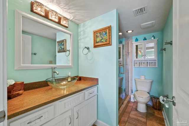 bathroom with tile patterned flooring, a shower, toilet, and vanity