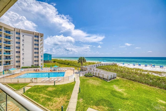 exterior space featuring a beach view, a lawn, and a water view