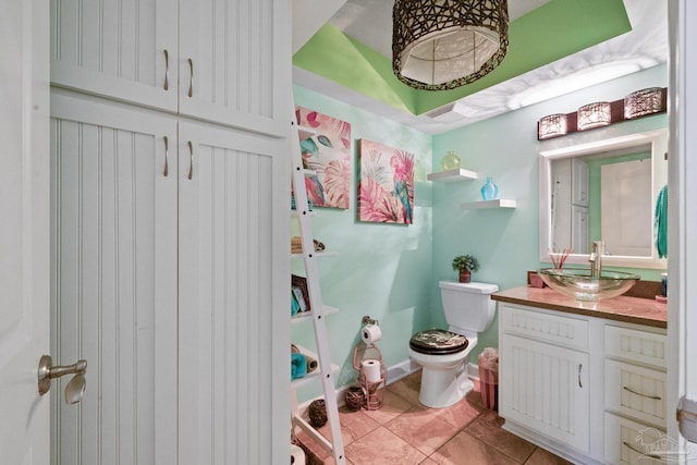 bathroom with toilet, vanity, and tile patterned floors