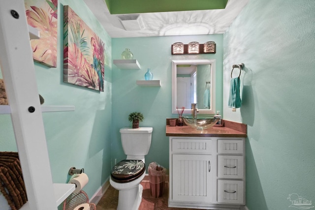 half bathroom with visible vents, vanity, and toilet