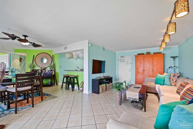 living room featuring ceiling fan, light tile patterned floors, crown molding, and a textured ceiling