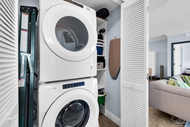 5 Portofino Dr Unit 703, Pensacola Beach, FL 32561 - washroom with stacked washing machine and dryer, ornamental molding, and tile patterned floors