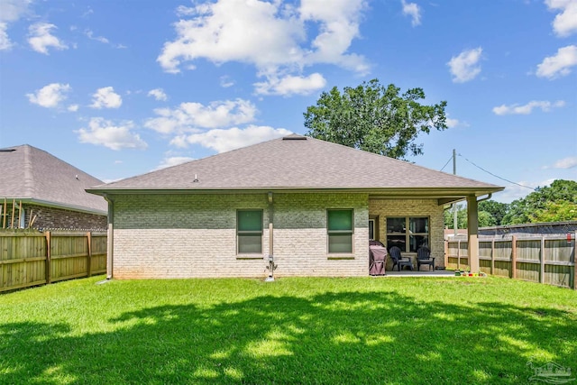 rear view of property featuring a patio and a yard