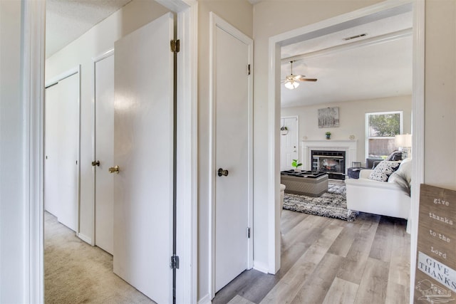 corridor featuring visible vents and light wood finished floors