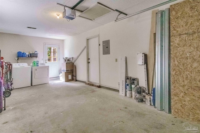 garage with washing machine and clothes dryer, a garage door opener, and electric panel