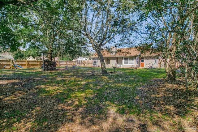 view of yard with a playground and a fenced backyard