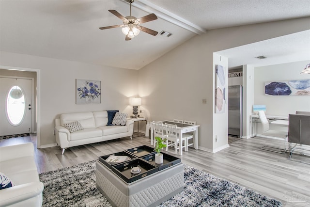 living room featuring visible vents, a ceiling fan, lofted ceiling with beams, wood finished floors, and baseboards