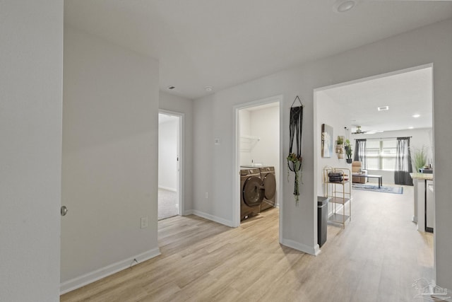 corridor featuring independent washer and dryer and light hardwood / wood-style flooring