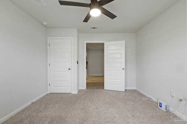 unfurnished bedroom with ceiling fan and light colored carpet