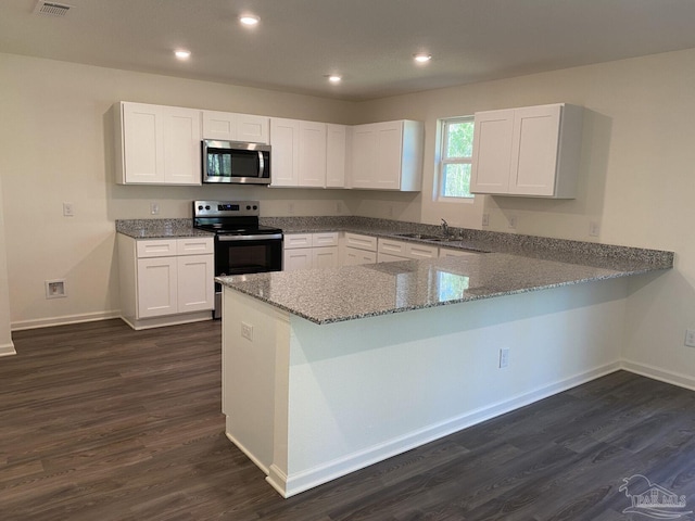 kitchen featuring kitchen peninsula, sink, white cabinetry, range with electric stovetop, and stone countertops