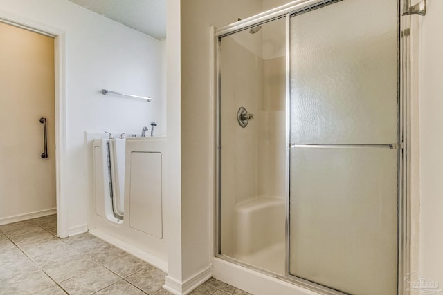 bathroom with shower with separate bathtub and tile patterned floors