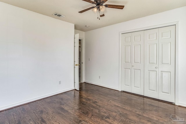 unfurnished bedroom with ceiling fan, a closet, and dark hardwood / wood-style flooring