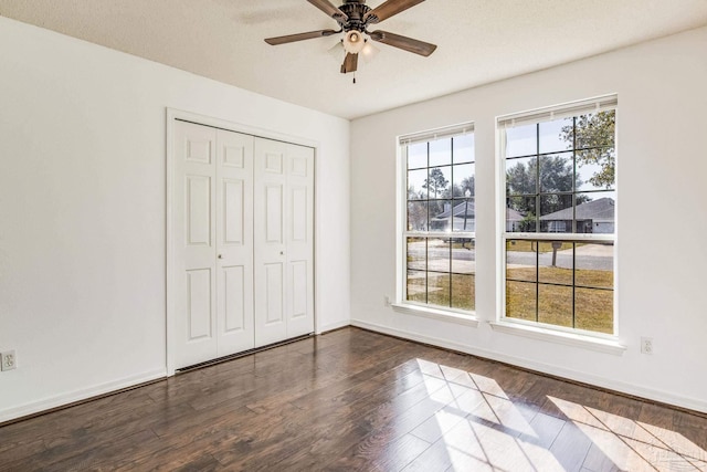 unfurnished bedroom with ceiling fan, a textured ceiling, hardwood / wood-style flooring, and a closet