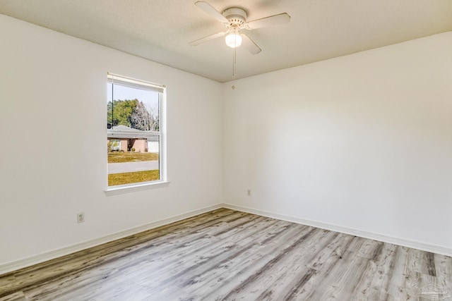 empty room with ceiling fan and light hardwood / wood-style floors