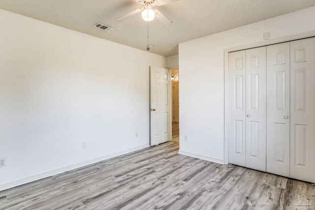 unfurnished bedroom with ceiling fan, a closet, and light hardwood / wood-style flooring