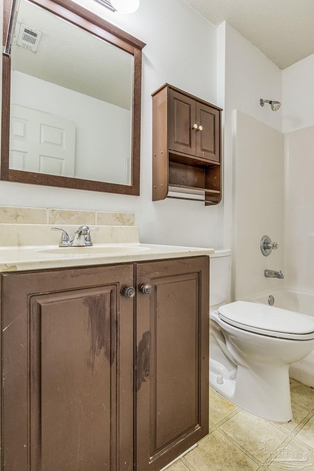 full bathroom with toilet, shower / tub combination, tile patterned flooring, a textured ceiling, and vanity