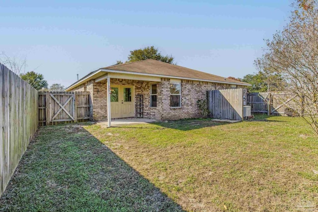 back of property featuring a patio area, central AC, and a lawn