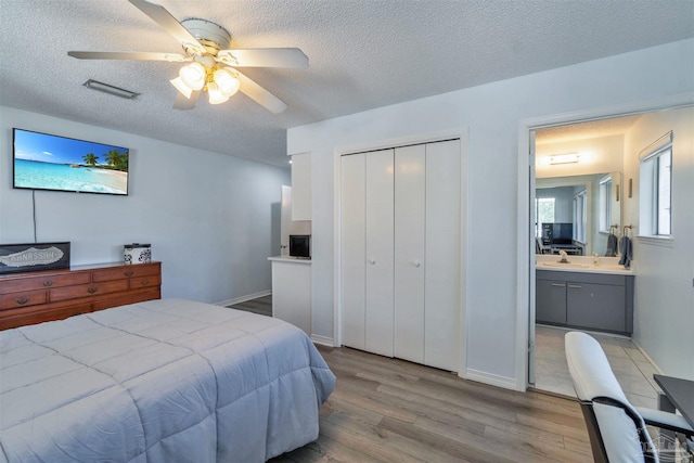 bedroom with visible vents, ceiling fan, wood finished floors, a textured ceiling, and a closet