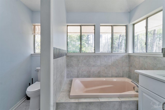 bathroom featuring vanity, a garden tub, toilet, and a healthy amount of sunlight