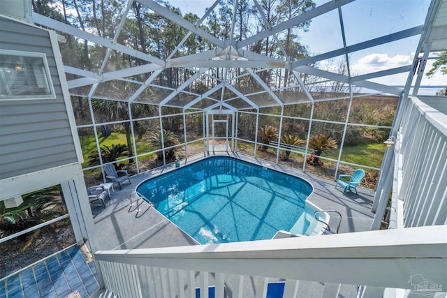 pool with a patio area and glass enclosure