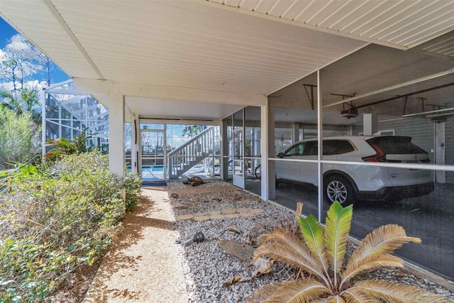 view of patio with glass enclosure, a pool, and a carport