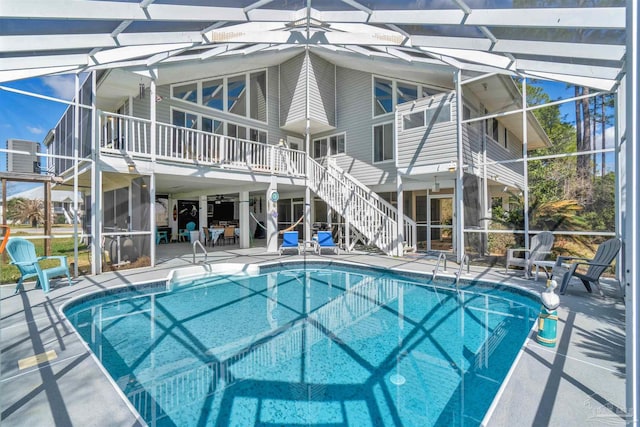 pool with a patio, stairway, cooling unit, and a lanai