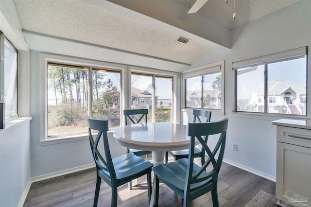 dining space featuring vaulted ceiling, dark wood-type flooring, visible vents, and baseboards