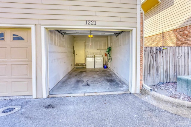 view of exterior entry with a garage and separate washer and dryer