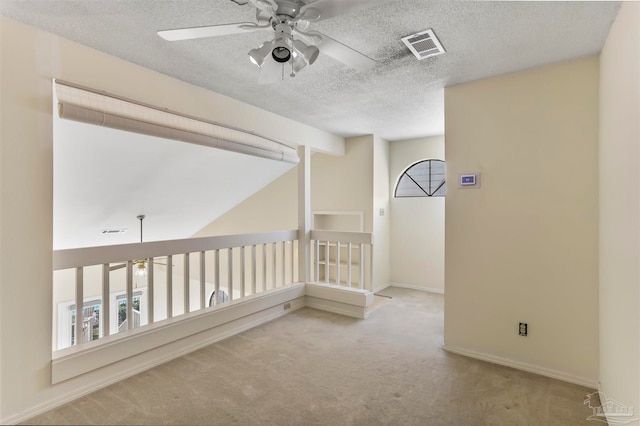 hallway with vaulted ceiling with beams, a textured ceiling, and light colored carpet