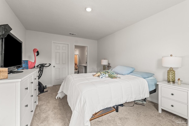 carpeted bedroom featuring ensuite bathroom