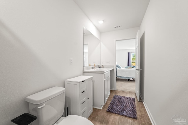 bathroom featuring vanity, hardwood / wood-style flooring, and toilet