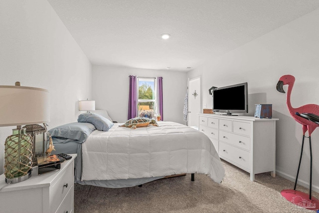 bedroom featuring light carpet and a textured ceiling