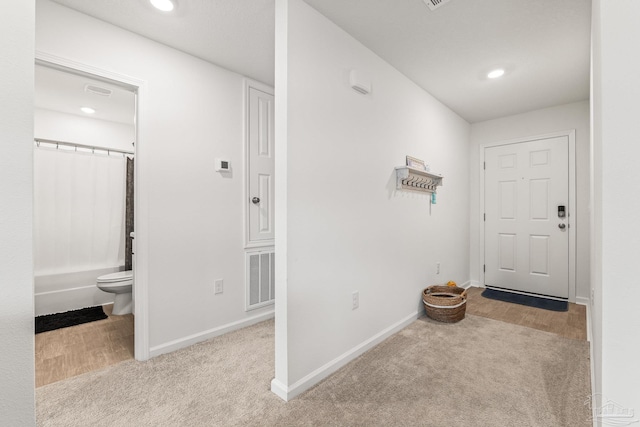 corridor featuring light colored carpet