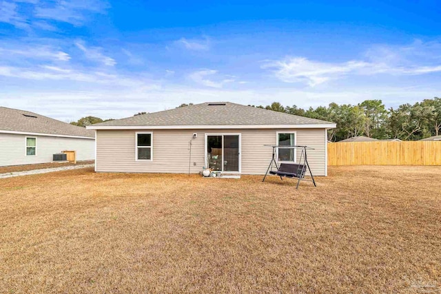 rear view of house with cooling unit and a yard