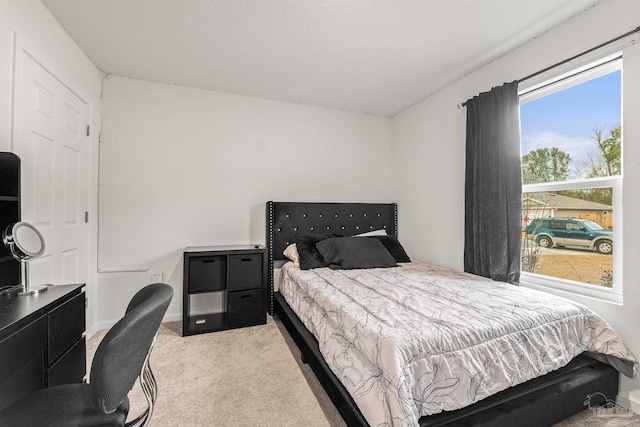 bedroom with light carpet and a textured ceiling