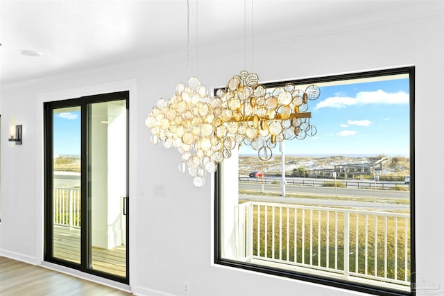 unfurnished dining area with crown molding, a healthy amount of sunlight, and light hardwood / wood-style floors