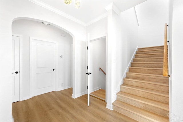 staircase with hardwood / wood-style flooring and crown molding