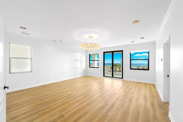 spare room with ornamental molding and light hardwood / wood-style floors