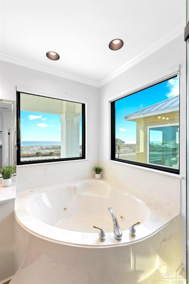 bathroom with crown molding and a tub