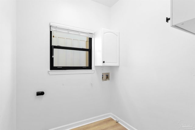 clothes washing area with washer hookup, wood-type flooring, and cabinets