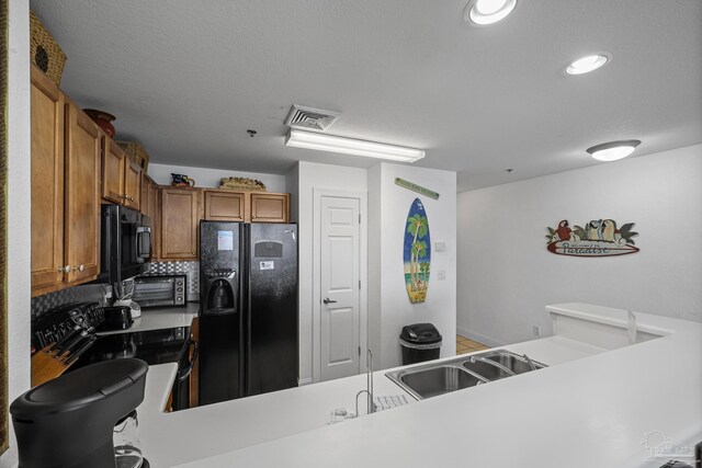 850 Ft Pickens Rd Unit 1230, Pensacola Beach, FL 32561 - kitchen featuring black appliances, a sink, brown cabinetry, light countertops, and recessed lighting