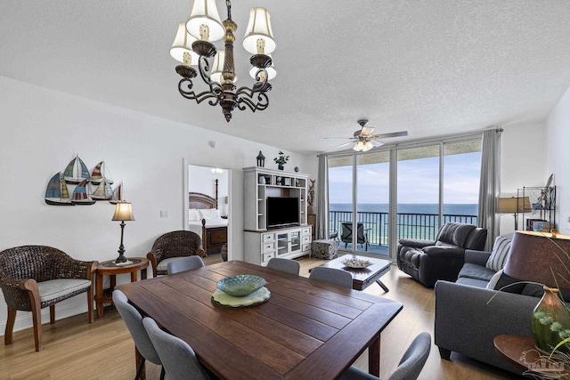 850 Ft Pickens Rd Unit 1230, Pensacola Beach, FL 32561 - dining room with light wood-style floors, expansive windows, a chandelier, a textured ceiling, and ceiling fan