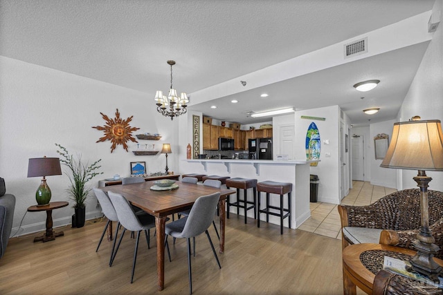 850 Ft Pickens Rd Unit 1230, Pensacola Beach, FL 32561 - dining area featuring a chandelier, light wood-style floors, baseboards, recessed lighting, and a textured ceiling
