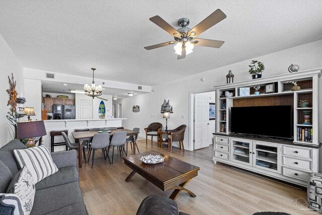 850 Ft Pickens Rd Unit 1230, Pensacola Beach, FL 32561 - living area with a chandelier, a textured ceiling, a ceiling fan, and light wood finished floors