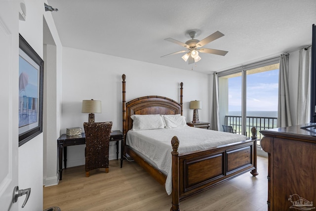 850 Ft Pickens Rd Unit 1230, Pensacola Beach, FL 32561 - bedroom with access to exterior, a water view, light wood-type flooring, a wall of windows, and ceiling fan