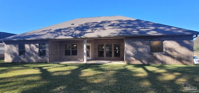 rear view of property with a patio, a yard, brick siding, and a shingled roof