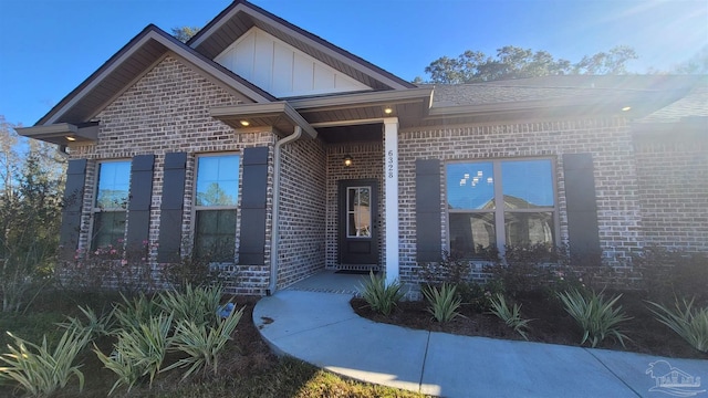 property entrance with brick siding and board and batten siding