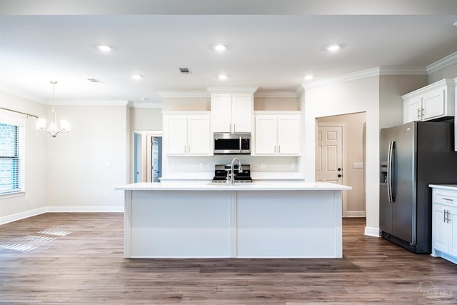 kitchen with visible vents, a sink, light countertops, appliances with stainless steel finishes, and crown molding